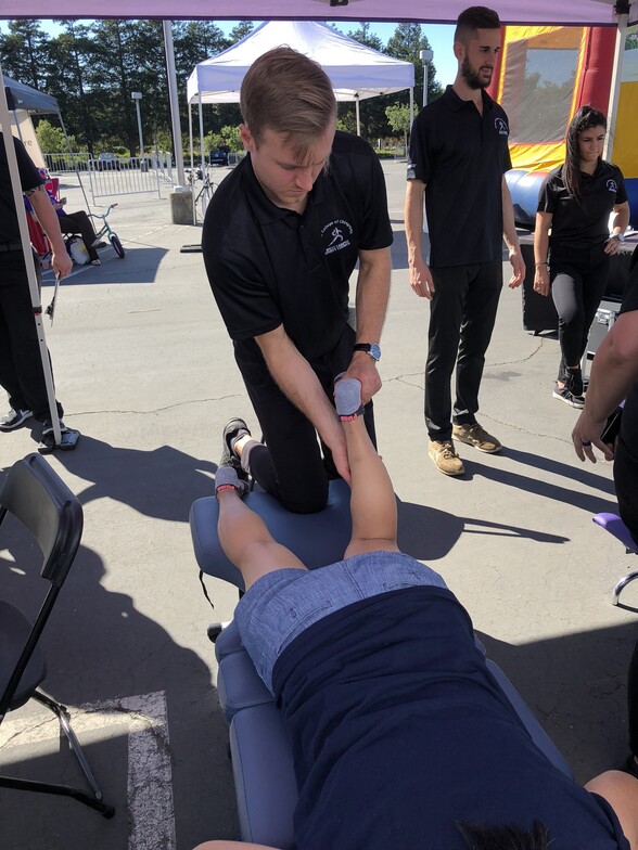 Dr. Adam Will is a Chiropractor treating a patient at a race when he was at school.